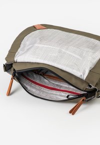 Borsa a tracolla verde oliva con apertura a zip, caratterizzata da interno a quadretti, cerniera con dettagli rossi e tiranti in pelle.