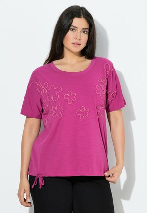 T-shirt fucsia con vestibilità morbida, caratterizzato da ricami floreali e un dettaglio con cordoncino all'orlo. Maniche corte e scollatura rotonda.
