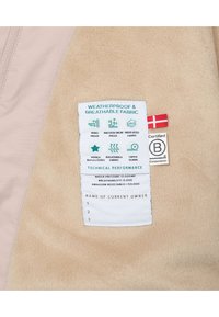 Beige fleece stof met een roze accent, met een wit label dat de weerbestendige eigenschappen en technische prestatiemetrics beschrijft.