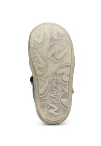 Sula med texturerad design i ljusbeige färg, graverad logotyp och cirkulära mönster. Mindre slitage är synligt.