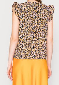 Blouse à imprimé floral avec manches à volants, dotée d'un fond noir et de fleurs jaunes, roses et blanches. Tissu doux, coupe décontractée.