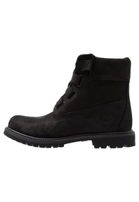 Black ankle boot made from suede with a textured side panel, lace-up design, padded ankle collar, and rubber sole featuring rugged treads.