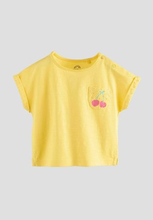 Gelbes kurzärmliges T-Shirt mit Rundhalsausschnitt. Verfügt über eine Tasche mit bestickten Kirschen und Zierlöchern entlang der Ärmel.