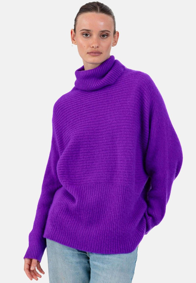Pull violet en maille côtelée avec un col montant, une coupe ample et des manches longues. Présente une texture horizontale et une silhouette décontractée.