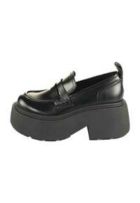 Melnas ādas mokasīnas ar izteiksmīgu biezā melnā platformas zole, kas satur šuvju dizainu un siksniņu pāri augšdaļai.