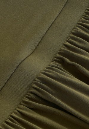 Olivgrüner Stoff mit einer glatten Textur weist auf einer Seite geraffte Details auf, die einen subtilen Kontrast in Form und Ausführung erzeugen.