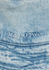 Jasnoniebieski kapelusz typu bucket z denimu o teksturowanym wykończeniu. Posiada dekoracyjne, wyszywane detale oraz haftowane logo "Marc O'Polo" z przodu.