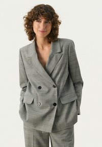 Grau kariertes, doppelt geknöpftes Blazerjacke mit breiten Revers, zwei Vorderaschen und schwarzen Knöpfen. Glatte Textur mit einem entspannten Schnitt.