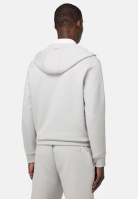 Lichtgrijze hoodie met een relaxte pasvorm, voorzien van een capuchon met drawstring, geribde mouwen en een vlakke naadontwerp. Geen zichtbare logo's of patronen.