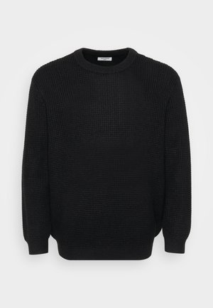 Maglione nero lavorato a maglia con un motivo testurizzato, scollo rotondo e maniche lunghe. Vestibilità ampia; polsini e orlo a coste.