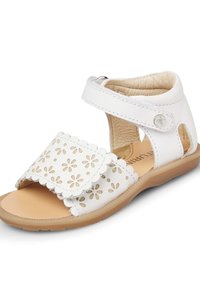 Sandalo in pelle bianca con intagli floreali, bordi scallop e cinturino regolabile. Suola marrone chiaro. Design aperto per favorire la traspirazione.