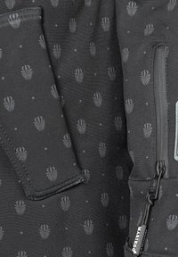 Svart tyg med ett subtilt tonalt mönster av abstrakta snäckmotiv, med en dragkedjeficka och kontrasterande sömdetaljer.