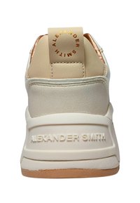 Baskets blanches et beiges avec un dessus en cuir lisse, un contrefort texturé et un logo rond à l'arrière. Comprend une semelle en caoutchouc et du branding.