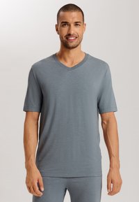 T-shirt grigio a V in tessuto leggero con maniche corte, texture liscia e vestibilità rilassata. Nessun motivo o dettaglio apparente.