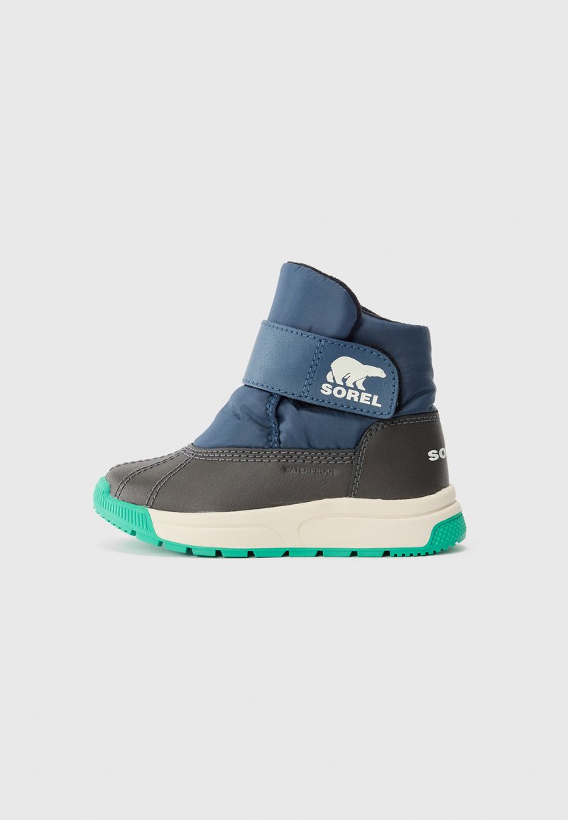 Wasserdichte Winterstiefel für Kinder in Marineblau und Grau mit grüner Sohle und einem Klettverschluss, der ein Eisbär-Logo und den Markennamen Sorel trägt.