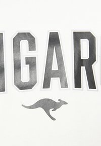 White fabric t-shirt featuring bold, textured black letters spelling "BIG AR" with a stylized gray kangaroo logo beneath.
