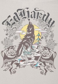 Grijze graphic t-shirt met een wolf die huilt tegen een gele maan, omringd door bloemen en twee gestileerde adelaars. Merkennaam opvallend weergegeven.