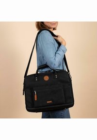 Schwarze Canvas-Laptoptasche mit Lederakzenten, Reißverschlussfronttasche, oberen Griffen und abnehmbarem Schultergurt. Glatte Textur und rechteckige Form.