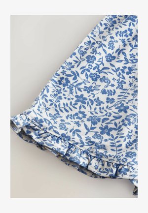 Witte stof met een blauwe bloemenprint met kleine bloemen en bladeren. De zoom heeft een gerimpelde rand voor extra detail.