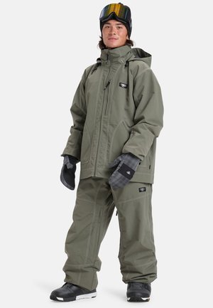 Tenue de snowboard en vert olive. Comprend une veste imperméable avec fermeture éclair, un pantalon assorti et des gants isolés avec des accents texturés.