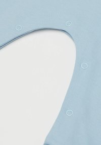 Světle modrá látka s žebrovanou strukturou, se zapínáním na patentky a kulatým výstřihem. Design je jednoduchý a funkční.