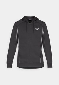 Svart hettegenser med glidelås og snorhette, hvite kontrastpiping, og Puma-logo på brystet. Laget av mykt, sportslig stoff.