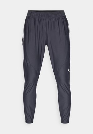 Schwarze Sporthose aus leichtem, glattem Material. Mit elastischem Bund, schmal zulaufenden Beinen und weißen Seitenstreifen. Logo nahe dem Saum.