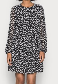 Schwarzes geblümtes Kleid mit langen, transparenten Ärmeln und einem runden Ausschnitt. Verfügt über einen gestuften, gerafften Saum und ein Muster aus kleinen weißen Blumen.