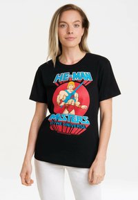 Black cotton t-shirt featuring a colorful He-Man graphic, displaying vibrant red and blue text and a cartoon character with a sword.