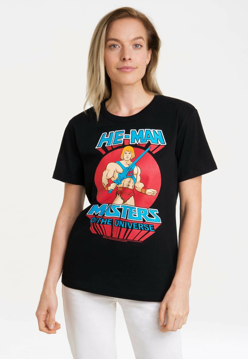 Black cotton t-shirt featuring a colorful He-Man graphic, displaying vibrant red and blue text and a cartoon character with a sword.