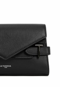 Pochette en cuir noir avec une finition texturée, rabat triangulaire et quincaillerie en forme de T en argent. Dotée d'une bandoulière amovible et d'un logo en relief.