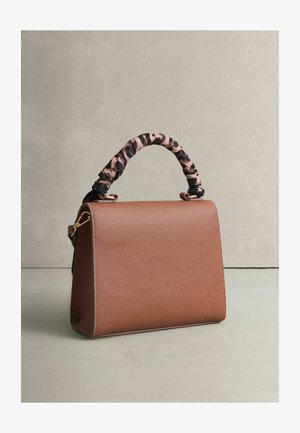 Bruine handtas met een textuur, voorzien van een handvat van roze en zwarte luipaardprint stof, met gouden hardware-accenten en een gestructureerde vorm.