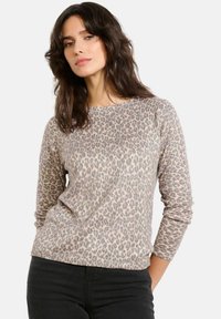 Bluzka z długim rękawem w panterkę, wykonana z miękkiej, fakturowanej tkaniny w odcieniach beżu i brązu, z okrągłym dekoltem i luźnym krojem.