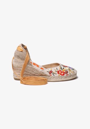Scarpa espadrille con zeppa ricamata in beige con motivi floreali, suola in juta naturale e accenti arancioni. Presenta un dettaglio in morbido cuoio marrone.