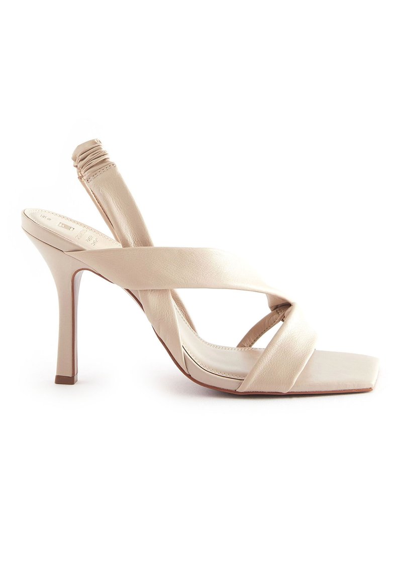 Beige High Heelsandalen mit Kreuzriemen aus glattem Leder. Mit einer quadratischen Zehenpartie und einem schlanken, konisch zulaufenden Absatz.