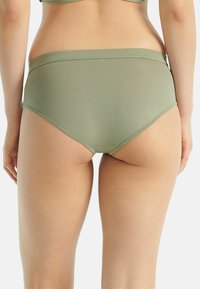 Culotte taille haute vert olive avec une texture lisse, une ceinture élastique douce et une conception sans coutures, présentant une coupe classique.