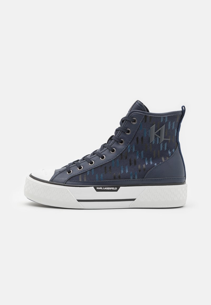 Baskets montantes en matériau texturé bleu marine avec un motif, bout en caoutchouc blanc et semelle épaisse blanche. Détail du logo noir.