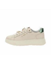 Beige lage sneakers met dikke zool, metallic groene hieltab, gouden studs en bloemenjuwelen als vetersdecoraties.