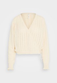 V-neck, cropped wrap sweater in light cream with a textured, knitted pattern. Features long sleeves with ruffled cuffs and a drawstring closure.