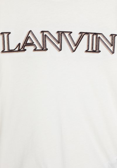 T-shirt en coton blanc avec un texte brodé sombre et proéminent indiquant "LANVIN" sur le devant dans une police en gras.