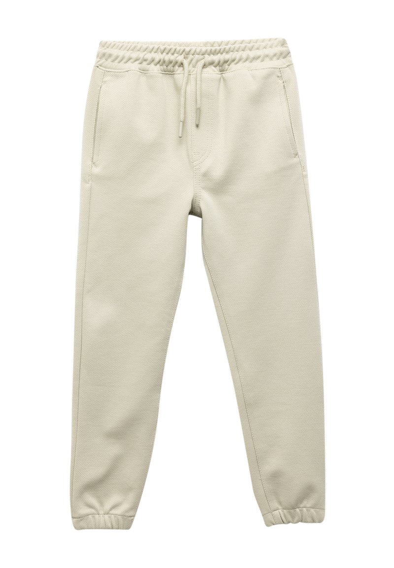 Beige joggingbroek met een elastische tailleband en trekkoord, voorzien van twee zijzakken, taps toelopende pijpen en een gestructureerde stofafwerking.