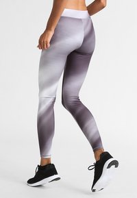 Legginsy w gradientowym wzorze od jasnoszarego do ciemnoszarego, z wysokim pasem i gładkim, elastycznym materiałem.