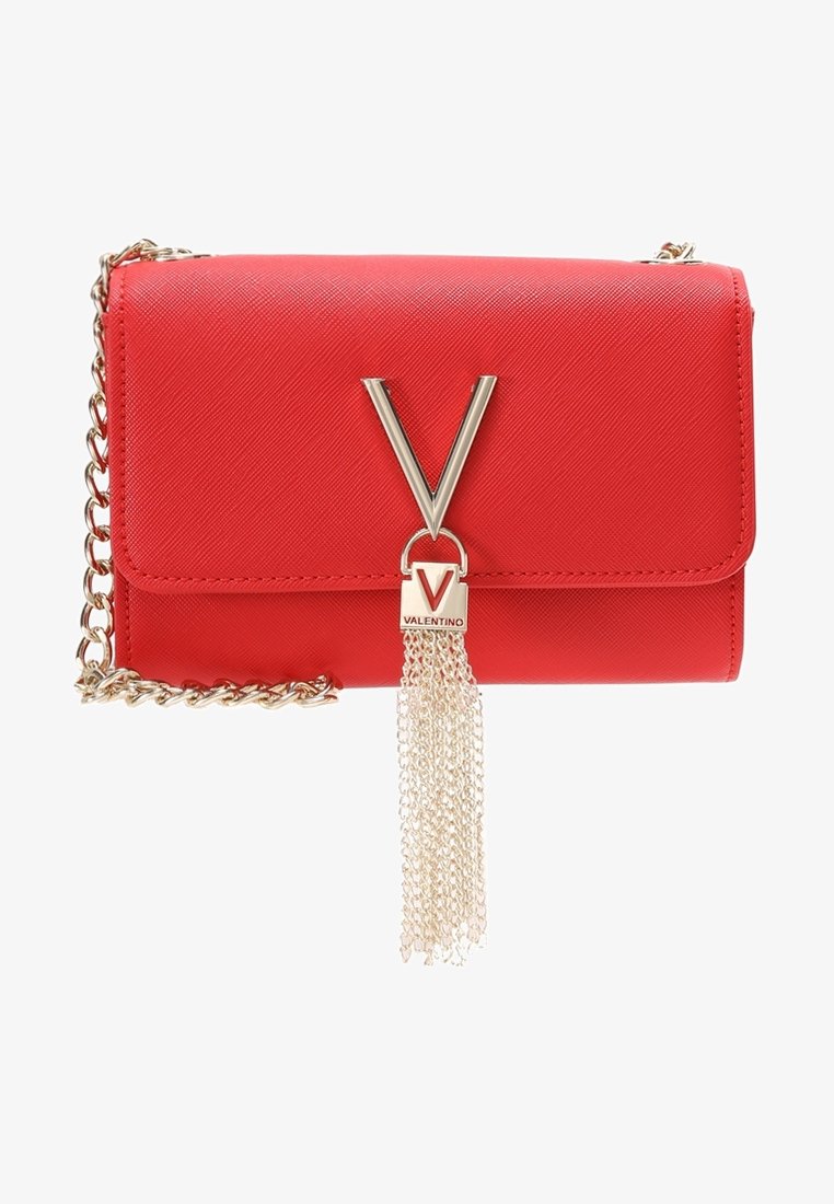 Sac à main en cuir rouge avec bandoulière en chaîne dorée, arborant un logo "V" argenté bien visible et un pompon constitué de chaînes dorées. Surface texturée.