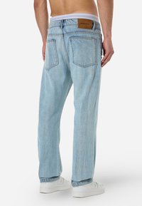 Φως μπλε τζιν παντελόνι με άνετη εφαρμογή, διαθέτοντας ζώνη και δύο πίσω τσέπες. Λεπτομέρειες ραψίματος στις τσέπες και στο τελείωμα.