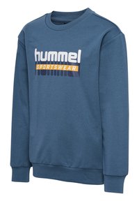 Blauwe sweatshirt gemaakt van een katoenmix. Voorzien van een ronde hals, geribbelde manchetten en een grafische print met het merk "hummel SPORTSWEAR".