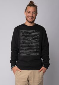 Black sweatshirt featuring a line art design with cat silhouettes on a horizontal wave pattern. Made from soft fabric, crew neck style.