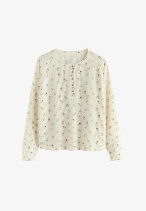 Långärmad, gräddfärgad tröja med ribbad struktur, utrustad med knapplugg och blommönster i pastellfärger.