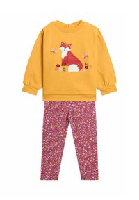 Mustársárga, hosszú ujjú felső, vörös rókát, pillangókat és virágokat hímzéssel díszítve, rózsaszín virágmintás leggings-szel párosítva.