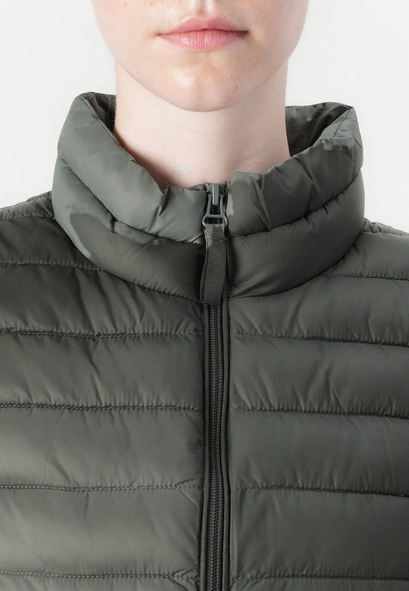 Dunkelgrüne, gepolsterte Jacke mit Stehkragen, vertikalen Nähten und einem Frontreißverschluss. Glattes, leichtes Material.