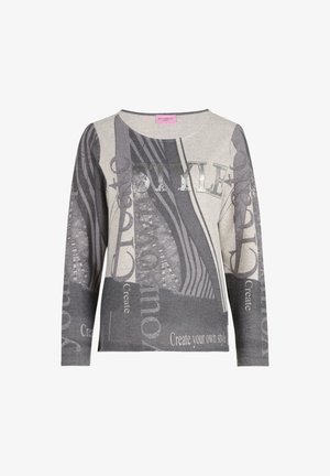 Pitkähihainen neule harmaassa ja beessissä, jossa on sekoitus kuvioita. Neuleessa on metallipainatuksella tekstit "TYYLIT" ja "Luo oma tyylisi".